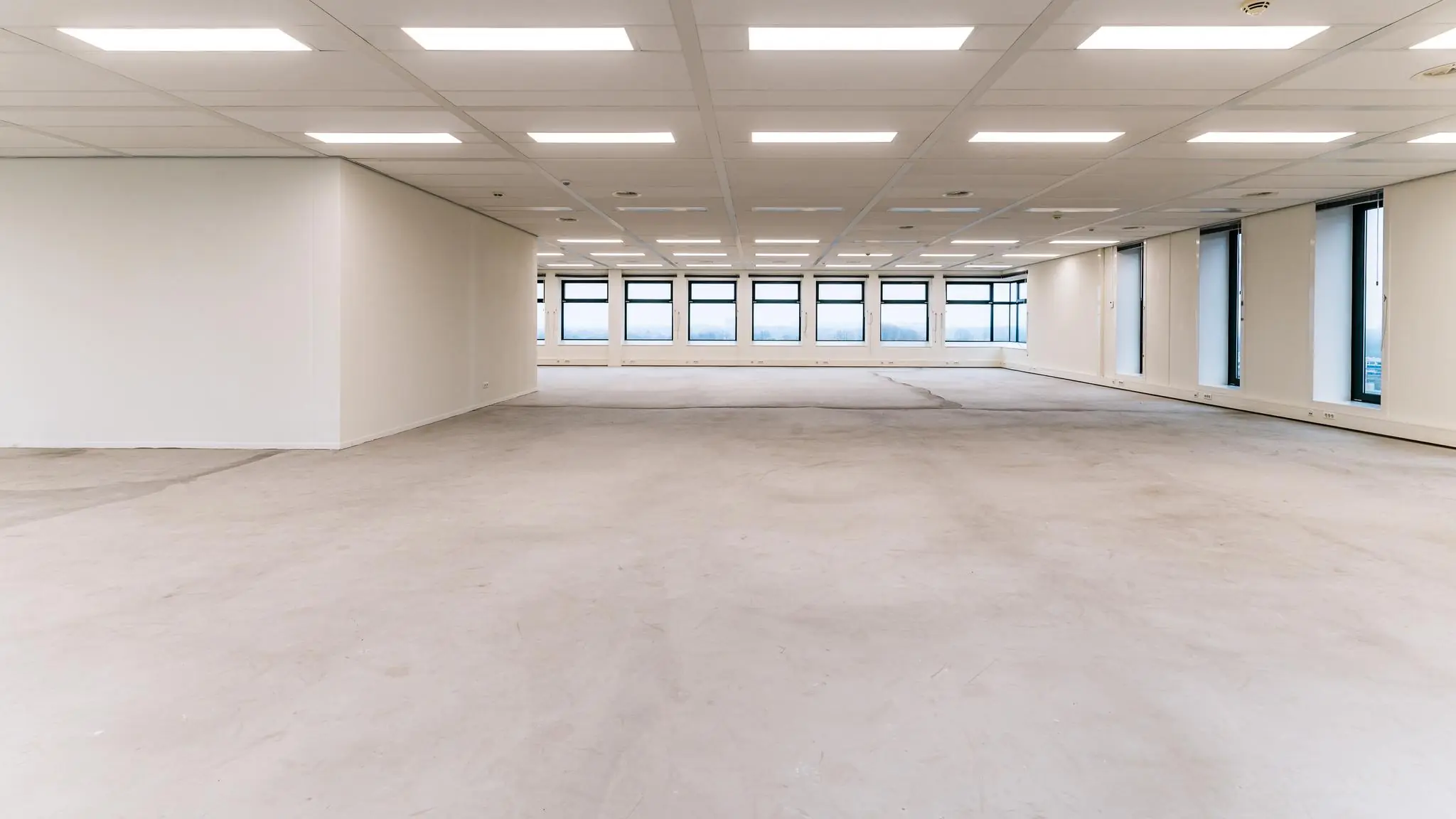 Leeg kantoorpand aan de George Hintzenweg met grote ramen en systeemplafond.